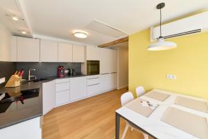 a kitchen with white cabinets and a dining table at Burgblick Appartement Riesling Gold in Bernkastel-Kues +20 photos
