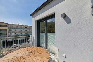 a patio with a table and an umbrella on a balcony at Burgblick Appartement Riesling Gold in Bernkastel-Kues