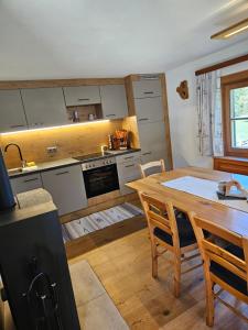 a kitchen with a wooden table and a dining room at Almhütte, Ferienhaus Hadn Hube in Paisberg
