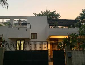 a white house with a fence in front of it at Home Away From Home in Kolhapur