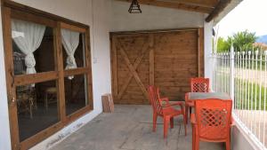 eine Terrasse mit einem Tisch und Stühlen sowie einer Holztür in der Unterkunft Casita Vaqueros in Vaqueros