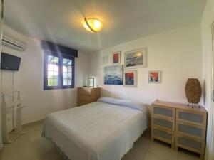 a white bedroom with a bed and a window at Relax Los veleros in Pasito Blanco