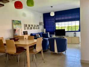 a living room with a table and blue chairs at Relax Los veleros in Pasito Blanco