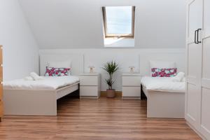 a white room with two beds and a window at Dom Nad Wodą - Smolarnia in Smolarnia