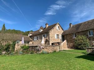 an old stone house with a grass yard at Gite Authentique Évasion in Saint-Mard-de-Vaux