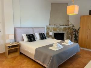 a bedroom with a bed with towels and a fireplace at The Beach House - Apartments & Studios in Afitos +93 photos