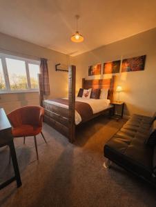 a bedroom with a bed and a chair and a couch at Grains Bar Hotel in Oldham +193 photos