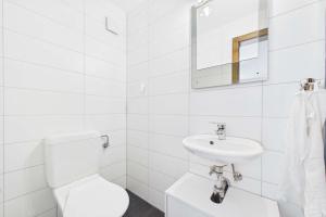 a white bathroom with a toilet and a sink at Cozy Studio in Brig in Gamsen