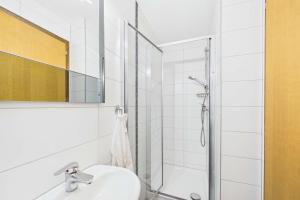 a white bathroom with a shower and a sink at Cozy Studio in Brig in Gamsen