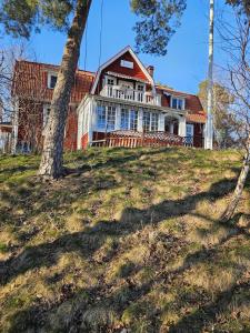 a house on top of a hill with a tree at Furubo in Orkelljunga