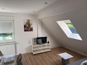 a living room with a tv and a window at StayKassel Apartment in Kassel