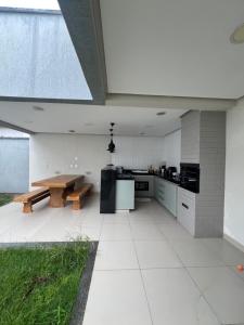 a large kitchen with a wooden table and a bench at Casa aconchegante in Imperatriz +1 photo