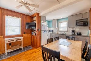 a kitchen with a table and chairs and a refrigerator at Bennett's Bungalow - S Nags Head MP 17, 30 Yds to Beach, Year Round Flex Stays in Whalebone