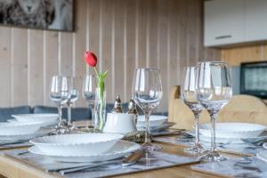 a table with wine glasses and a rose in a vase at U Podnóża Tatr - duży dom z widokiem na Tatry blisko Zakopanego in Biały Dunajec
