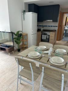 a kitchen with a wooden table with chairs and a refrigerator at Apartamento Mar Blava Chilches in Chilches