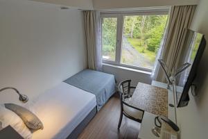 a bedroom with a bed and a table and a window at Hotel Landgoed Zonheuvel in Doorn