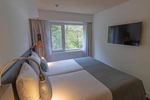 a bedroom with a large bed and a window at Hotel Landgoed Zonheuvel in Doorn