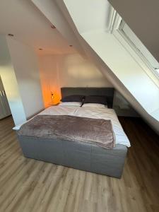 a bed in the middle of a attic bedroom at StayKassel Apartment in Kassel