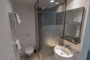 a bathroom with a shower and a toilet and a sink at Hotel Landgoed Zonheuvel in Doorn +25 photos