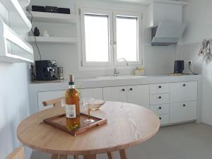 a kitchen with a wooden table with a bottle of wine at ÉLYSÉE Boutique in Katavatí +8 photos