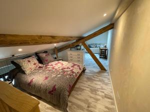 a bedroom with a bed in a attic at Le Chai d'Auguste in Pauilhac