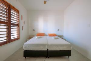 a bedroom with a bed in a white room at Casa Iguana in Trairi +31 photos