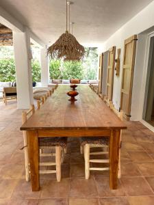a dining room with a large wooden table and chairs at Finca LA SELVA, Exclusive Villa in Benimussa in San Antonio