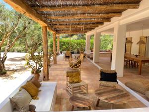 an outdoor patio with a couch and chairs at Finca LA SELVA, Exclusive Villa in Benimussa in San Antonio