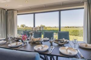 a dining room table with chairs and a large window at 5 Bed in Hereford oc-78646 in Madley
