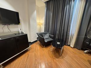 a living room with a chair and a flat screen tv at CNS Hotels in Ghaziabad