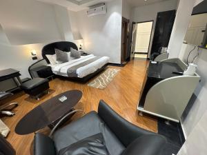 a hotel room with a bed and a desk and chairs at CNS Hotels in Ghaziabad