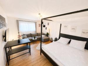 a bedroom with a bed and a desk and a couch at Studio Weidenkorb in Vaihingen an der Enz
