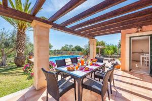 a patio with a table and chairs and a pool at Casa Catalina in Felanitx