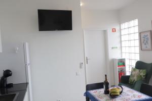 a living room with a television and a table with a bottle of wine at Fifty`s House 1 By Sam Houses in Ribeira Brava +7 photos