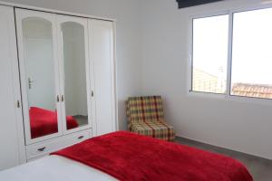 a bedroom with a bed and a chair and a cabinet at Fifty`s House 1 By Sam Houses in Ribeira Brava