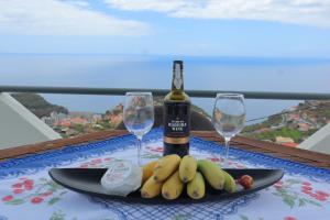 a table with a plate of bananas and a bottle of wine at Fifty`s House 1 By Sam Houses in Ribeira Brava