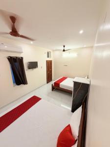 a room with a bed and a tv on a wall at HARI HARA HOMEs in Rāmeswaram +5 photos