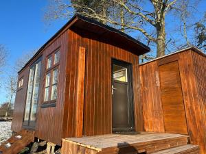 ein kleines Holzhaus auf einer Holzplattform in der Unterkunft Solvognen in Pejrup