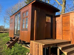 ein kleines Holzhaus mit Veranda und Rampe in der Unterkunft Solvognen in Pejrup + 15 Fotos