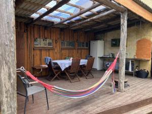 eine Hängematte auf einer Terrasse mit Tisch und Stühlen in der Unterkunft Solvognen in Pejrup