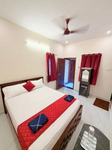 a bedroom with a large bed with a red blanket at HARI HARA HOMEs in Rāmeswaram