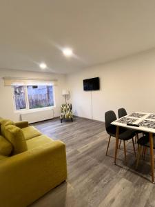 a living room with a yellow couch and a table at Refugio Austral in Punta Arenas