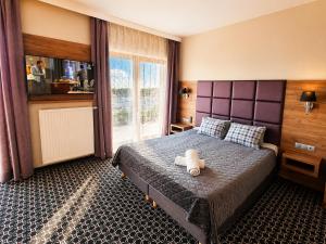 a bedroom with a bed with a teddy bear on it at Villa Malibu in Zegrze Południowe +12 photos
