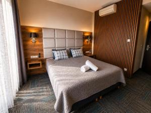 a bedroom with a bed with two towels on it at Villa Malibu in Zegrze Południowe