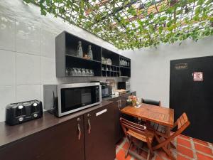 a kitchen with a table and a microwave at Balcón Paisa SAS in Medellín +20 photos