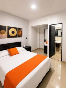 a bedroom with a large bed and a bathroom at Balcón Paisa SAS in Medellín