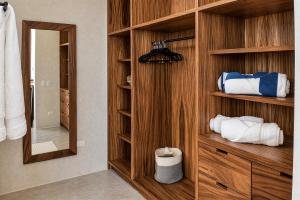 a bathroom with a wooden closet with towels at Ocean view terrace and saltwater pool group getaway in Todos Santos
