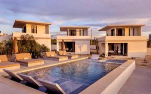 a villa with a swimming pool in front of a house at Sun-drenched escape w sleek saltwater pool in Todos Santos