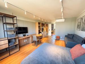 a living room with a couch and a tv at Studio equipado com Piscina espaço histórico. in Rio de Janeiro