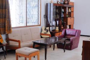 a living room with a couch and a table and a guitar at Atlasio House in Kasri +2 photos
